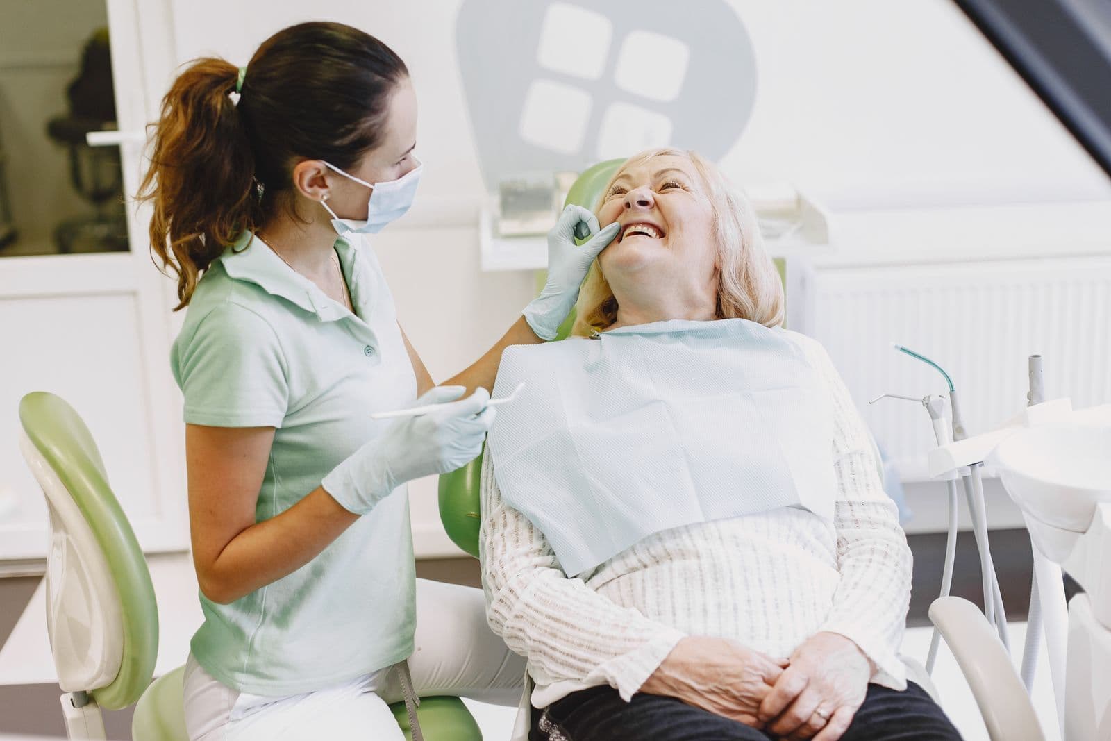 Dentist and a smiling older patient during a check-up