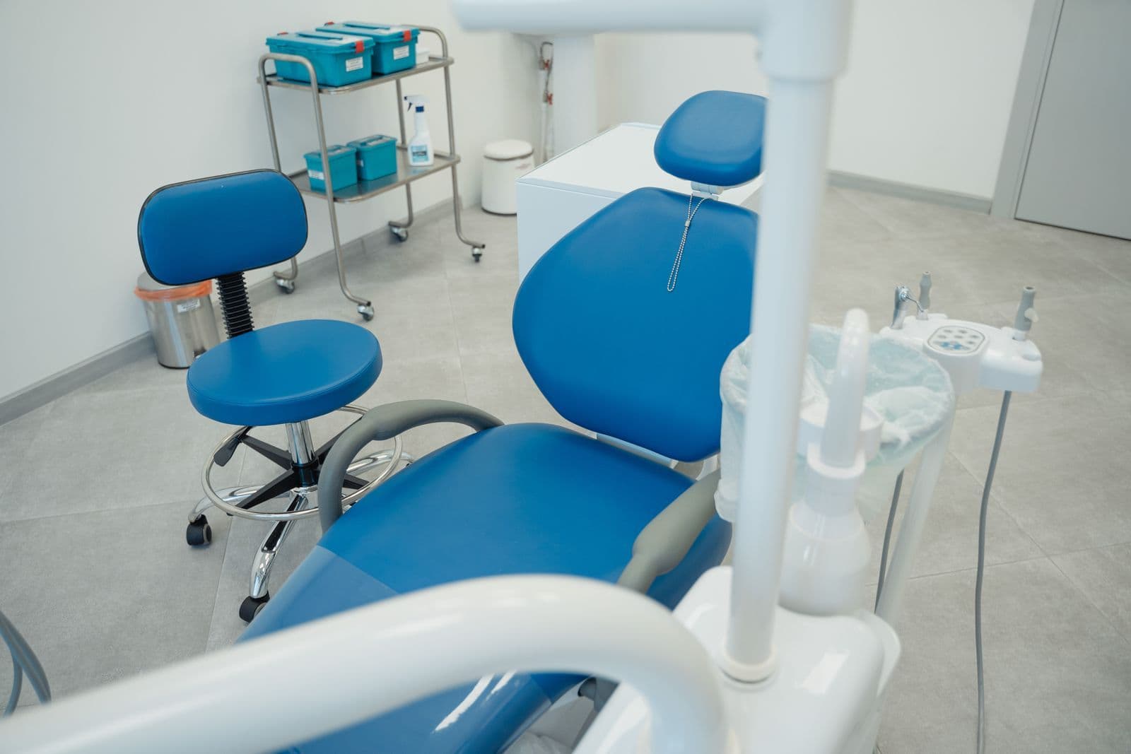 Empty treatment room with a blue dental chair