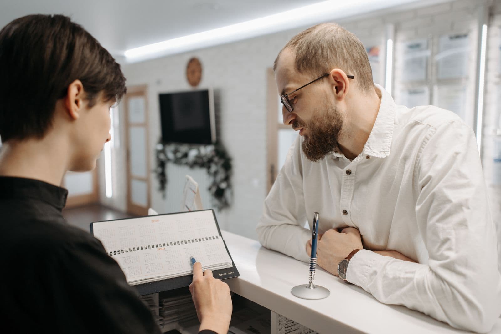 Receptionist booking a patient in at the front desk